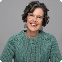 Mary Roy Glasses Green Sweater Headshot