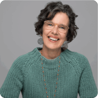Mary Roy Glasses Green Sweater Headshot